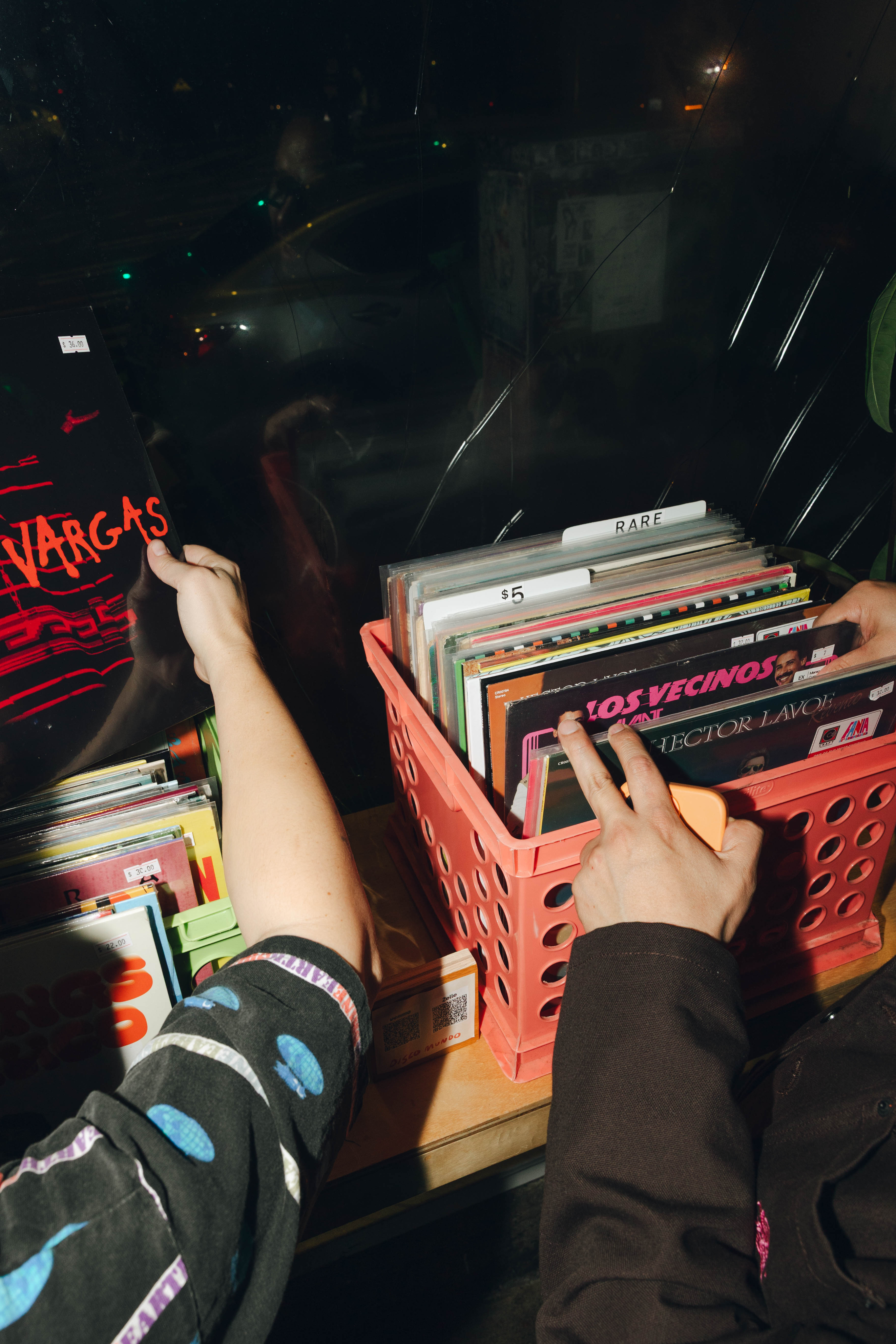Two women sitting at a modern table talking with a city view behind them.